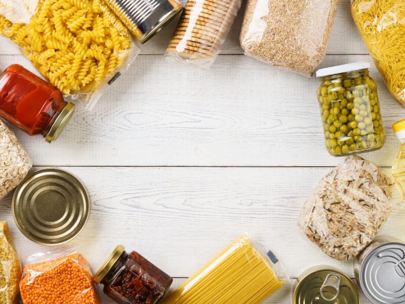 various-uncooked-cereals-grains-pasta-canned-food-white-wooden-table-ingredients-cooking-frame-background-with-copy-space